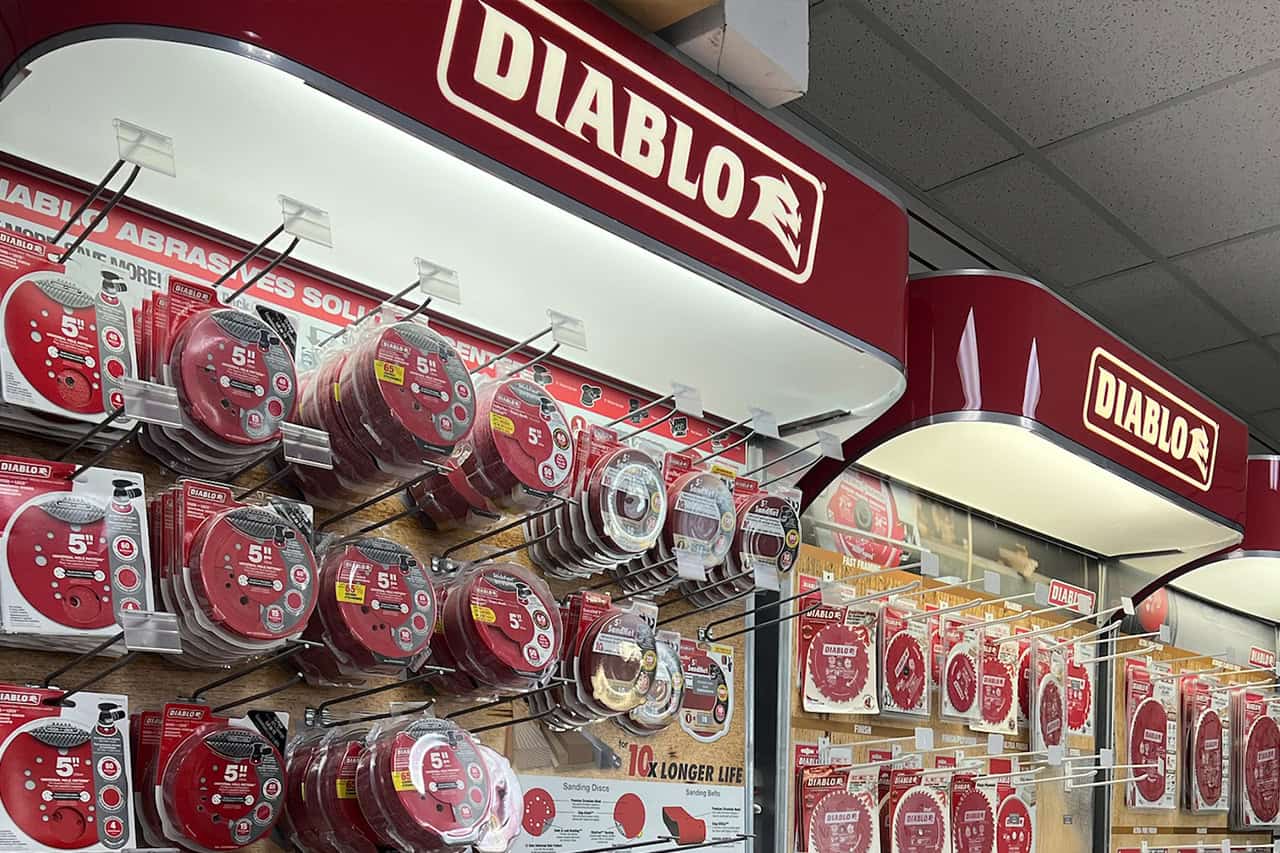 A Scott's Hill Hardware store display of Diablo brand abrasive wheels and blades showcases various sizes and types, mounted on a wooden pegboard and metal hooks, with branded red signage above.