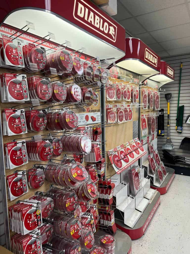 A store display at Scott's Hill Hardware features various Diablo brand sanding discs and other abrasive products neatly arranged on shelves. The display includes multiple sizes and types of sanding discs in distinctive red packaging.