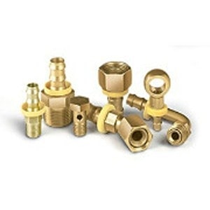 A variety of brass plumbing fittings, including elbows, connectors, and adaptors, are arranged randomly at Scott's Hill Hardware.