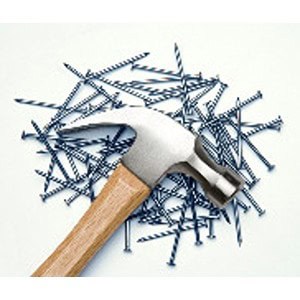 A hammer with a wooden handle is resting on a scattered pile of screws on a white surface, available at Scott's Hill Hardware.