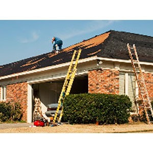 A person is installing shingles on a house roof, with two ladders leaned against the roof and tools from Scott's Hill Hardware scattered nearby.